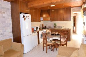 a kitchen with a table and a white refrigerator at The Love Holiday House in Tris Elies
