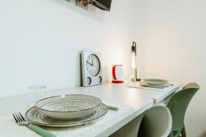 a kitchen counter with plates and a clock on the wall at Silvia's Luxury Suites by RentMax in Canegrate