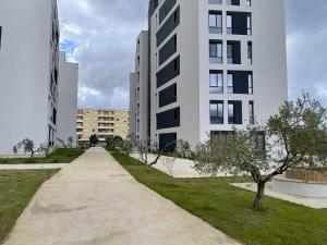 a walkway in a city with tall buildings at Sunset Apartment in Orikum