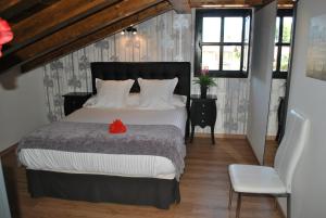 a bedroom with a bed with a red flower on it at Apartamentos Spa Casco Historico de Isla in Isla