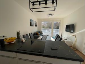 a kitchen and living room with a black counter top at Appartement Eveline Pörtschach in Pörtschach am Wörthersee
