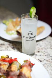 ein Teller Essen und ein Glas Wasser mit einer Limette in der Unterkunft La Moraleja Love hotel in Mexiko-Stadt