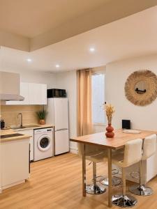a kitchen with a wooden table and white appliances at Hyper-centre Toulon in Toulon