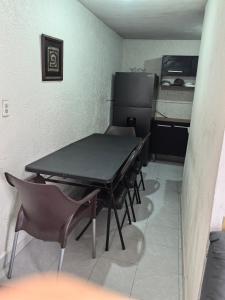 a room with a table and chairs and a refrigerator at Casa Constructor staff colaboradores in Cabo San Lucas