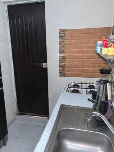 a kitchen with a sink and a black door at Casa Constructor staff colaboradores in Cabo San Lucas +3 photos