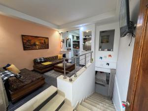 a living room with a couch and a staircase at Duplex raffiné avec entrée privée in Tunis
