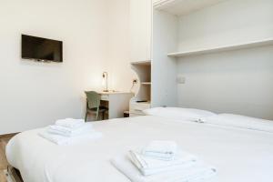 a bedroom with a white bed with towels on it at Silvia's Luxury Suites by RentMax in Canegrate