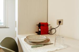 a white table with a plate and a red appliance at Silvia's Luxury Suites by RentMax in Canegrate