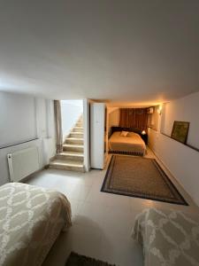a hotel room with two beds and a staircase at Duplex raffiné avec entrée privée in Tunis