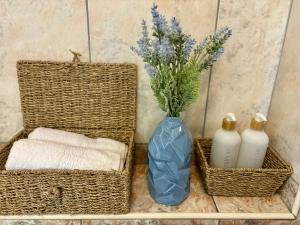 a blue vase with a bouquet of flowers and two baskets at Apartment Fortuna in Korčula +36 photos