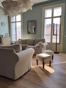 a living room with a couch and a table and windows at Spacieux et lumineux duplex arty au centre de Sète in Sète
