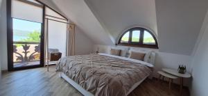 a bedroom with a large bed and a large window at Pensiunea Casa Sobarului in Molovata +5 photos