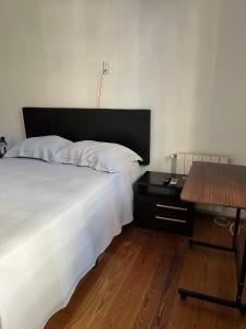 a bedroom with a bed and a wooden table at Casa en Pocitos in Montevideo