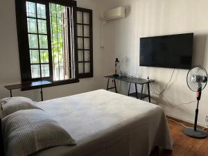 a bedroom with a bed and a flat screen tv at Casa en Pocitos in Montevideo
