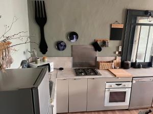 a kitchen with a stove top oven next to a window at Spacieux et lumineux duplex arty au centre de Sète in Sète