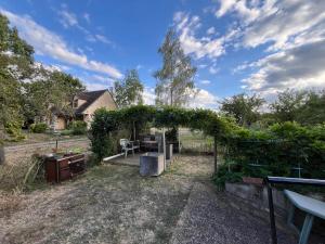 a garden with an arch with a table and a house at Maison de Georges et Paulette in Bouesse