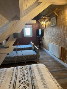 a attic room with a bed and a staircase at Maison de Georges et Paulette in Bouesse