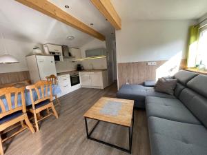 a living room with a blue couch and a table at Mathilde - Lastering Ferienhäuser & Apartments in Wettringen