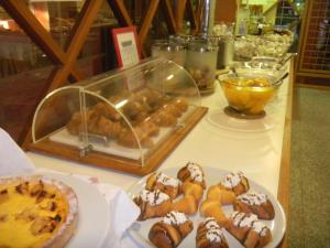 a table with plates of pastries and a tray of food at Hotel Carol & Residence Grazia in Rimini +9 photos