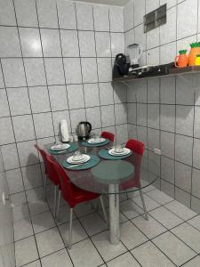 a table with four red chairs in a kitchen at Apartamento próximo da Praça Mestre Dominguinhos in Garanhuns +13 photos