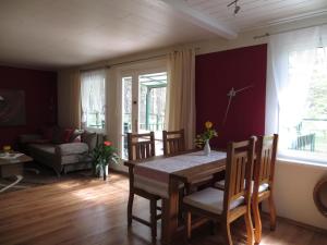 a dining room with a table and chairs and a couch at Kastavengrund - Ferienhäuser mit Kamin in Lychen