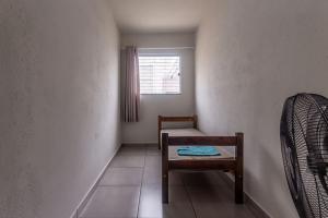 a small room with a chair and a window at Apto para 8 pessoas com Garagem e Churrasqueira in Pará de Minas