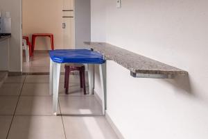 a counter with a stool and a table and a blue seat at Apto para 8 pessoas com Garagem e Churrasqueira in Pará de Minas +12 photos