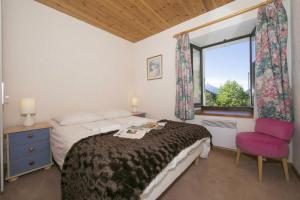 a bedroom with a bed and a window and a chair at Résidence Igloo in Le Tour