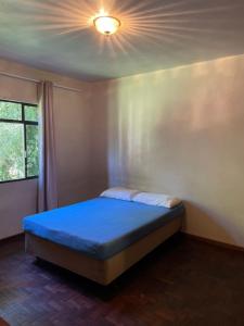 a bedroom with a bed with a light on the ceiling at Memora Guesthouse Bateias - Casa Inteira ou quartos em chácara in Campo Largo