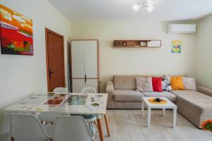 a living room with a couch and a table at Positive Apartment - Слънчев уют и голяма веранда в сърцето на Петрич in Petrich