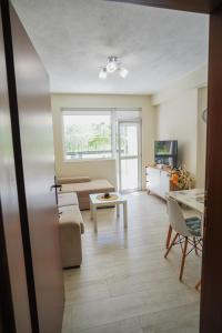 a living room with a couch and a table at Positive Apartment - Слънчев уют и голяма веранда в сърцето на Петрич in Petrich