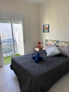 a blue teddy bear sitting on top of a bed at La Casita de Kai in El Médano +18 photos