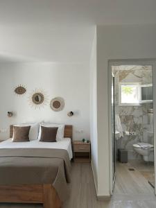 a bedroom with a bed and a bathroom with a mirror at Fiosal Apartments 3 in Skiathos