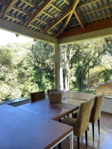 a wooden table and chairs on a patio at Memora Guesthouse Bateias - Casa Inteira ou quartos em chácara in Campo Largo