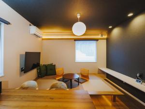 a living room with a table and chairs at tonaResort Furano in Furano