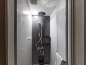 a bathroom with a shower with a glass door at tonaResort Furano in Furano +61 photos