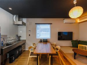 a kitchen and dining room with a wooden table at tonaResort Furano in Furano