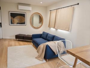 a living room with a blue couch and a table at Stylish 2, 3 and 5 Bedroom Entire Homes Near Art Deco and LA Hotspots in Los Angeles