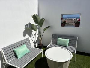 two benches in a room with a table and a plant at La Casita de Kai in El Médano