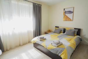 a bedroom with a bed with towels on it at Positive Apartment - Слънчев уют и голяма веранда в сърцето на Петрич in Petrich