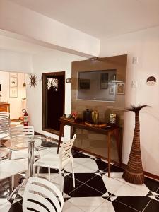 a dining room with white chairs and a table and a vase at Boutique Hotel Casa Teatro in Manaus