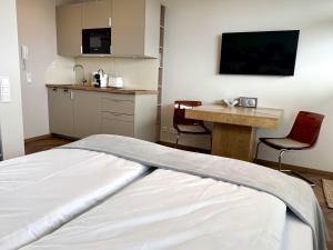 a room with a bed and a desk and a kitchen at Boje in Westerland