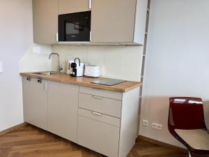 a small kitchen with a sink and a microwave at Boje in Westerland +12 photos
