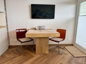 a wooden table in a room with two chairs at Boje in Westerland