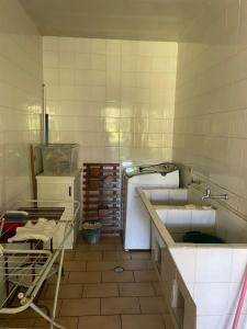 a dirty kitchen with a sink and a stove at Memora Guesthouse Bateias - Casa Inteira ou quartos em chácara in Campo Largo