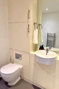 a white bathroom with a toilet and a sink at New,London Hideaway Studio in Woking +44 photos