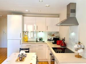 a kitchen with white cabinets and a white refrigerator at New,London Hideaway Studio in Woking