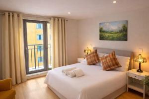 a bedroom with a large white bed with a window at New,London Hideaway Studio in Woking