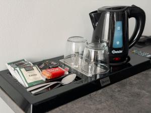 a counter with a coffee pot and glasses on it at MiDaMi 24h Hotel Self-Checkin in Schwanau