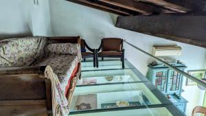 a glass floor with a couch and a chair at Il Pollaio di Pilade in Lerici